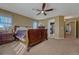 Bright main bedroom with a large bed, ceiling fan, and view into the bathroom at 5338 Potentilla St, Brighton, CO 80601