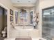 Elegant bathroom with a soaking tub, shutters, tile, and separate glass shower at 5540 Horseshoe Trl, Sedalia, CO 80135
