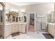 Well-lit bathroom with dual vanities, tile flooring, and mirrors at 5540 Horseshoe Trl, Sedalia, CO 80135