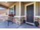 Inviting front porch with stonework, a bench, and potted plants at 42396 Glen Abbey Dr, Elizabeth, CO 80107