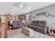 Spacious living room with brown leather reclining sofas and a view into the kitchen at 42396 Glen Abbey Dr, Elizabeth, CO 80107