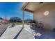 Covered back patio with a barbecue, small table with stools and view of the backyard at 42396 Glen Abbey Dr, Elizabeth, CO 80107