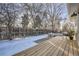 Backyard deck with seating, trees, and partial snow coverage at 1150 W Caley Ave, Littleton, CO 80120