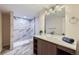 Modern bathroom featuring a walk-in shower, tiled floors, and a decorative lighting fixture at 1150 W Caley Ave, Littleton, CO 80120