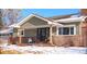 Inviting front exterior featuring a brick and siding facade, covered porch, and well-maintained landscaping at 1150 W Caley Ave, Littleton, CO 80120