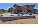 Outdoor patio with a stone fire pit, blue patio furniture, and covered outdoor kitchen at 1315 W 141St Cir, Westminster, CO 80023