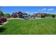 Aerial view of a home with a manicured lawn, pool, and lush landscaping at 1315 W 141St Cir, Westminster, CO 80023