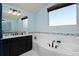 This bathroom features a soaking tub and vanity with dark wood cabinets at 1315 W 141St Cir, Westminster, CO 80023