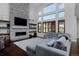 Spacious living room with a stone fireplace, large windows, and comfortable gray sectional seating at 1315 W 141St Cir, Westminster, CO 80023