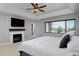 Sunlit bedroom with fireplace, mounted TV, and beautiful window view at 1315 W 141St Cir, Westminster, CO 80023