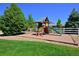 Backyard playground with slide, swings, and ladder surrounded by a grassy yard at 1315 W 141St Cir, Westminster, CO 80023