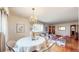 Elegant dining area featuring hardwood floors, a modern chandelier, and views into the living room at 2300 Joliet St, Aurora, CO 80010