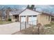 The side exterior view features a two-car garage and a fenced yard with a well-manicured lawn at 2300 Joliet St, Aurora, CO 80010