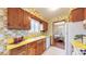 Retro kitchen with wooden cabinets, yellow countertops, and floral wallpaper at 2300 Joliet St, Aurora, CO 80010
