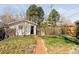 Backyard with brick pathway, green lawn, and small storage building at 309 S Hudson St, Denver, CO 80246
