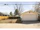Exterior view of a detached garage with a white door and a fenced yard at 309 S Hudson St, Denver, CO 80246