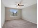 Cozy bedroom with a ceiling fan, a large window overlooking the neighborhood, and soft, neutral carpet at 23539 E Ida Dr # C, Aurora, CO 80016
