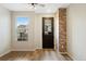 Entryway with wood-look floors, brick accent wall, ceiling fan, and view of the neighborhood through the window at 23539 E Ida Dr # C, Aurora, CO 80016