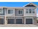 Attractive townhome with stone accents, gray siding, and individual garages, offering curb appeal and convenience at 23539 E Ida Dr # C, Aurora, CO 80016