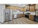 Well-lit kitchen features stainless steel appliances, wood cabinets, granite countertops, and modern flooring at 23539 E Ida Dr # C, Aurora, CO 80016