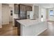 Modern kitchen island with white countertop, stainless steel refrigerator, and dark brown cabinets at 24811 E 33Rd Dr, Aurora, CO 80019