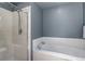 Bright bathroom featuring a glass-enclosed shower and a soaking tub with tile surround at 2737 Ulster St, Denver, CO 80238