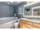 Well-lit bathroom with a double sink vanity, a soaking tub, and a window for natural light at 2737 Ulster St, Denver, CO 80238