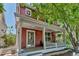 Charming red two-story home with a welcoming front porch and beautifully landscaped yard at 2737 Ulster St, Denver, CO 80238