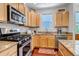 This kitchen features stainless steel appliances, granite counters, and wood cabinets at 2737 Ulster St, Denver, CO 80238