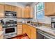 This kitchen features stainless steel appliances, granite counters, and wood cabinets at 2737 Ulster St, Denver, CO 80238