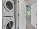Convenient laundry area with stacked washer and dryer, offering space-saving functionality in the home at 2737 Ulster St, Denver, CO 80238