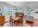 Open concept living room and dining area with hardwood floors, large windows, and a ceiling fan at 2737 Ulster St, Denver, CO 80238