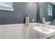 This powder room features white wainscoting, a pedestal sink, and blue-gray walls at 2737 Ulster St, Denver, CO 80238