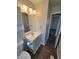 Bright bathroom featuring a white single sink vanity with wood-look flooring and updated lighting at 5552 Abilene St, Denver, CO 80239