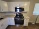 Close up of kitchen with white cabinets and new stainless steel oven and microwave at 5552 Abilene St, Denver, CO 80239