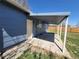 A covered back patio of a home with blue vinyl siding and a concrete slab. A wooden fence is along the property line at 5552 Abilene St, Denver, CO 80239