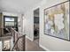 Hallway leading to laundry room featuring front loading washer/dryer, abstract wall art, and office with exterior view at 1787 W 166Th Ave, Broomfield, CO 80023