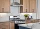 Modern kitchen features stainless steel appliances, light wood cabinetry, and gray countertops at 1787 W 166Th Ave, Broomfield, CO 80023