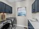 Laundry room with modern appliances, navy cabinets, and artwork at 1787 W 166Th Ave, Broomfield, CO 80023