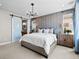 Main bedroom with a sliding barn door leading to the main bathroom, with chandelier and natural light from windows at 1787 W 166Th Ave, Broomfield, CO 80023