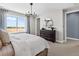 Bright main bedroom with a modern chandelier, dresser and round mirror, and natural light from a large window at 1787 W 166Th Ave, Broomfield, CO 80023