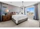 Bright main bedroom with a textured accent wall, contemporary chandelier, and natural light from large windows at 1787 W 166Th Ave, Broomfield, CO 80023