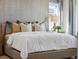 Bright main bedroom with a textured accent wall, contemporary chandelier, and natural light from large windows at 1787 W 166Th Ave, Broomfield, CO 80023