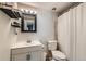 Bathroom with a modern vanity, framed mirror, and a shower with white shower curtain at 9943 Croke Dr, Denver, CO 80260