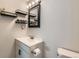 Stylish bathroom featuring a white vanity, black fixtures, and wall shelves at 9943 Croke Dr, Denver, CO 80260