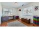 Bright bedroom with wood floors, desk, bench, and purple accent chair at 9943 Croke Dr, Denver, CO 80260