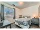 Cozy bedroom with a full-sized bed, nightstand, stylish grey bedding and window with blinds at 9943 Croke Dr, Denver, CO 80260