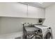 Functional laundry room with modern appliances, storage cabinets, and ample space at 9943 Croke Dr, Denver, CO 80260