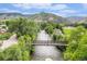 Scenic exterior view of a tranquil river flowing beneath a bridge, surrounded by lush greenery and majestic mountains at 16259 W 10Th Ave # K-3, Golden, CO 80401