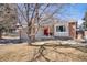 Charming two-story home with brick accents, red door, and mature tree in the front yard at 3321 S Dunkirk Way, Aurora, CO 80013